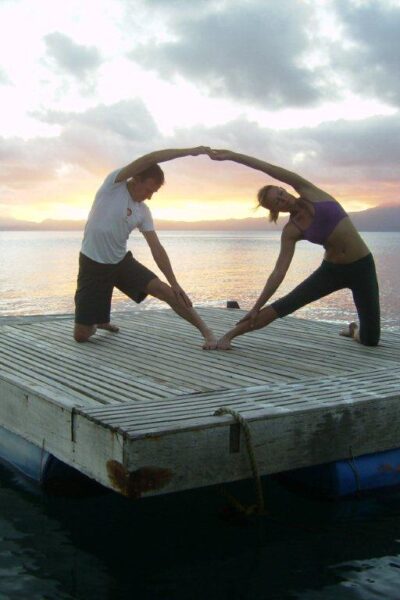 A couple practicing yoga on a fishing pontoon at Daku Resort, Savusavu.